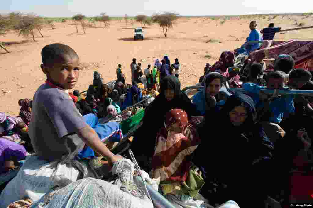 A child sits atop a truck loaded with Malian refugees and their belongings on the edge of the M&#39;Berra refugee camp in Mauritania, March 6, 2013. (Nyani Quarmyne/MSF)