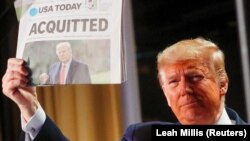 Predsednik Donald Tramp drži u ruci izdanje novina USA Today na čijoj naslovnoj piše "Oslobođen"