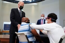 U.S. President Joe Biden puts his hand on a man's shoulder during a visit to a coronavirus disease vaccination site at Virginia Theological Seminary in Alexandria, Virginia, April 6, 2021.