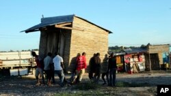 Men carry a mobile shop to safer ground in Pemba city on the northeastern coast of Mozambique, April, 27, 2019. Authorities are urging people to move immediately to higher ground as flooding and mudslides are feared in the wake of Cyclone Kenneth.