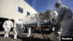 FILE - Participants of an exercise on transporting and handling contagious patients move a colleague during a simulation at a military airport outside of Rome, Sept. 24, 2014.