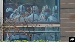 រូបឯកសារ៖ សមាជិក​នៃ​ក្រុម​អង្គការ​សុខភាព​ពិភពលោក ត្រូវបាន​គេ​មើល​ឃើញ​តាម​បង្អួច ក្នុង​អំឡុងពេល​ធ្វើ​ទស្សនកិច្ច​នៅ​មជ្ឈមណ្ឌល​គ្រប់គ្រង និង​បង្ការ​ជំងឺ​សត្វ Hubei នៅ​ក្នុង​ទីក្រុង Wuhan ក្នុង​ខេត្ត Hubei នៅ​ភាគកណ្តាល​ប្រទេស​ចិន កាលពី​ថ្ងៃទី២ ខែកុម្ភៈ ឆ្នាំ២០២១។