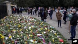 Warga meletakkan bunga di luar Kastil Windsor dekat London untuk mengenang Pangeran Philip, hari Minggu (11/4).