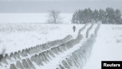 FILE - Ukrainian servicemen check newly build anti-tank fortifications and razor wire, amid Russia’s attack on Ukraine, near Russian border in Chernihiv region, Ukraine, January 10, 2024. (REUTERS/Gleb Garanich)