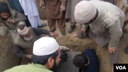 Pakistanski seljani nose jednu od žrtava Talibana u jednoj školi u Pešavaru