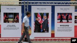 FILE - Photos of the summit between U.S. President Donald Trump and North Korean leader Kim Jong Un are displayed in Seoul, South Korea, Sept. 19, 2018. 