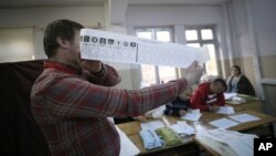 Un officiel tient un vote avec un vote pour le parti au pouvoir, le parti Justice et Développement, AKP, lors du dépouillement du vote lors d'un scrutin aux élections locales, à Istanbul, le dimanche 31 mars 2019. 