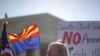Charles Balogh demonstrates in front of the Supreme Court in Washington as the court holds a hearing on Arizona's "show me your papers" immigration law, April 25, 2012.