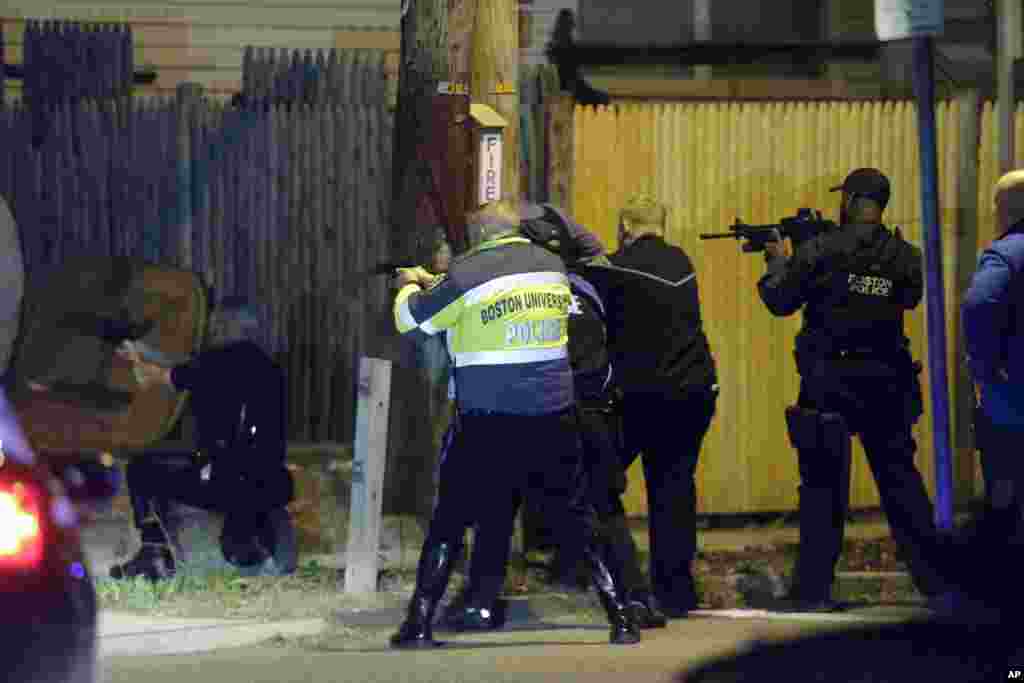 Police officers aim their weapons in Watertown, April 19, 2013.