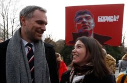 Prague's mayor Zdenek Hrib and Zhanna Nemtsova, daughter of Russian opposition figure Boris Nemtsov smile after unveiling a sign renaming the square where the Russian Embassy is located in Prague, Feb. 27, 2020.