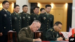 美军参联会主席邓福德上将（前左）与中国中央军委联合参谋部参谋长房峰辉在北京签署协议。 （2017年8月15日）