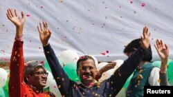 Ketua Partai Aam Aadmi (AAP) dan kandidat Gubernur New Delhi, Arvind Kejriwal (tengah) memberikan salam kepada para pendukungnya seusai memenangkan pemilu (10/2). 