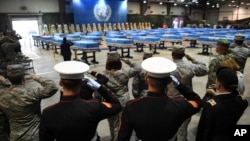 U.S. soldiers salute during a repatriation ceremony for the remains of U.S. soldiers who were killed in the Korean War and collected in North Korea, at the Osan Air Base in Pyeongtaek, South Korea, Wednesday, Aug. 1, 2018. A total of 55 containers will be returned to Hawaii for a second special ceremony. 