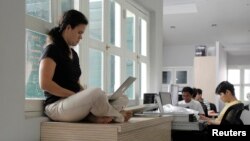 FILE - Employees are seen working on their computers at an office in Singapore May 24, 2012. Singapore placed first in a list of technologically advanced countries as ranked by a just released World Economic Forum report. 