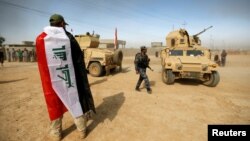 A soldier wears an Iraqi flag after the liberation of Khalidiya village from Islamic State militants south of Mosul, Iraq, Oct. 20, 2016. 