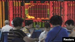 Para investor di depan papan elektronik yang menunjukkan informasi harga saham di Shanghai, China (Foto: dok).