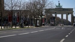 An almost empty road leads towards the Brandenburg Gate in Berlin, Germany, March 24, 2020.