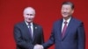 Presiden Rusia Vladimir Putin dan Presiden China Xi Jinping berjabat tangan saat konser memperingati 75 tahun hubungan diplomatik antara Rusia dan China serta pembukaan Tahun Kebudayaan China-Rusia di Pusat Seni Pertunjukan Nasional di Beijing, China, 16 Mei 2024. (Foto: via AP)