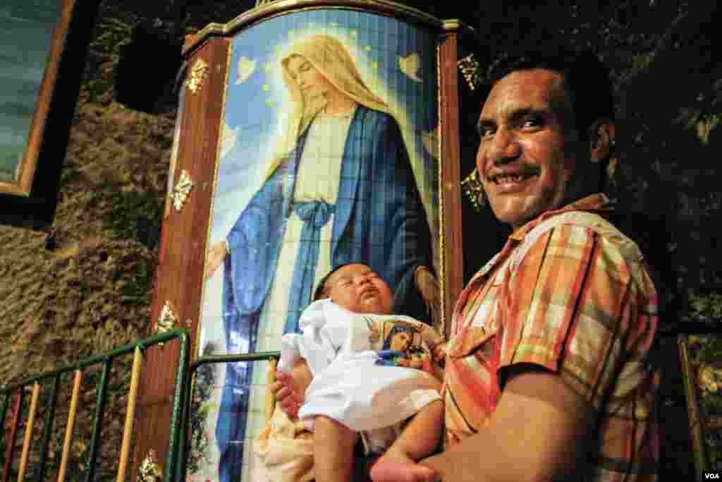 Saad Saleb 36, says while he holds his son Kirolos “I came here for blessings and seeing my family who lives in other provinces, they all came to meet here.” in Assiut, Egypt, August 20, 2017. (H. Elrasam/VOA)
