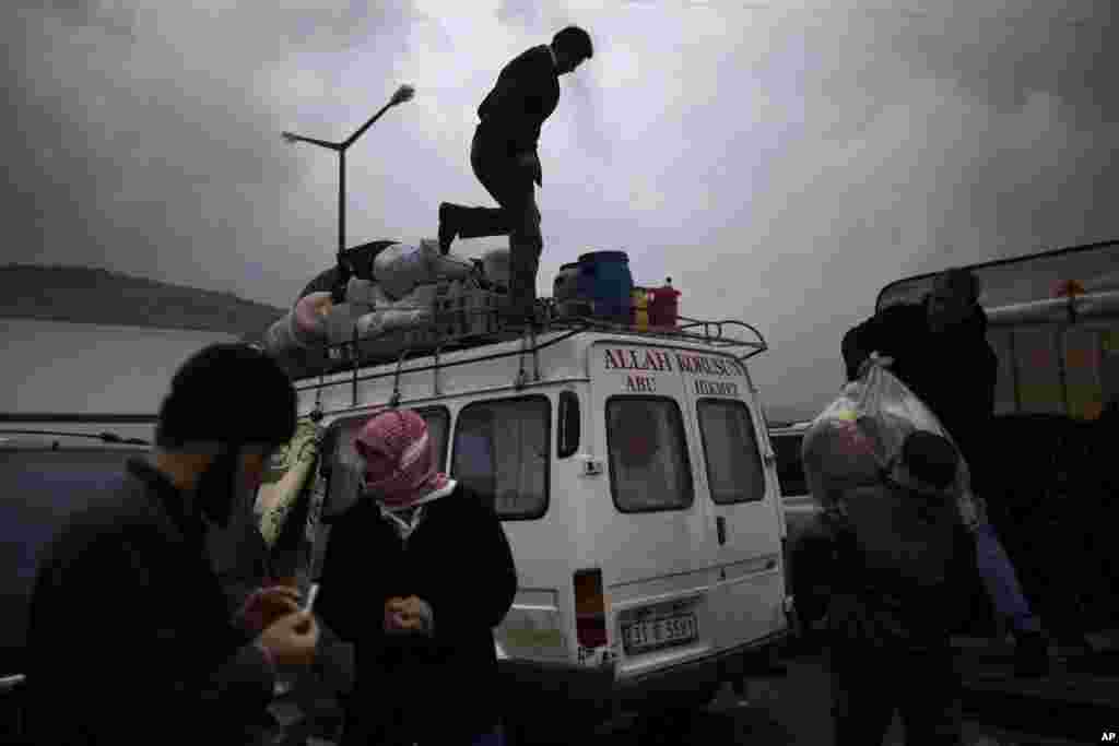 Syrian refugees,who fled their home in Idlib due to a government airstrike, load their belongings into a vehicle after crossing into Cilvegozu, Turkey, December 20, 2012.