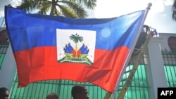 FILE - Workers place flags on a wall at the National Palace in the Haitian capital Port-au-Prince, on Feb. 6, 2017.