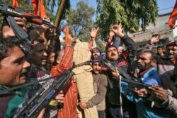 FILE - Supporters of Shiv Sena, a Hindu hardline group, shout slogans as they hold toy guns and an effigy depicting a Pakistani soldier during a protest in Jammu January 11, 2013.