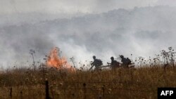 Israeli firefighters put out flames in a field after rockets launched from southern Lebanon landed on the outskirts of Katzrin in the Israel-annexed Golan Heights on June 2, 2024.