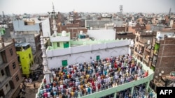 Muslim devotees offer Friday prayers at a mosque following sectarian riots over India's new citizenship law, at Mustafabad area in New Delhi. 