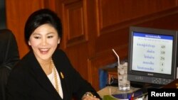 Perdana Menteri Thailand Yingluck Shinawatra tersenyum di tengah proses pemungutan suara untuk mosi tidak percaya di Bangkok (28/11).