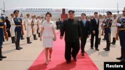 North Korean leader Kim Jong Un and his wife Ri Sol Ju walk upon arriving in Beijing, China, in this undated photo released June 20, 2018 by North Korea's Korean Central News Agency. 