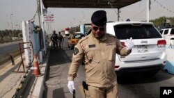 Seorang petugas kepolisian federal Irak menggunakan alat pendeteksi bom di pos pemeriksaan di Baghdad, Irak, 11 Oktober 2014. 