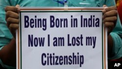 An activist holds a placard during a rally in solidarity with those affected by the final draft of the National Register of Citizens (NRC) in the northeastern state of Assam, in Kolkata, India, Aug. 1, 2018. 