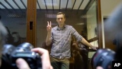 ফাইল ছবি—প্রয়াত রুশ বিরোধী দলীয় নেতা অ্যালেক্সেই নাভালনি কাঁচের ভেতর থেকে হাত তুলে আছেন। বাবুসকিংস্কি জেলা আদালত। মস্কো, ফেব্রুয়ারি ২০,২০২১। 