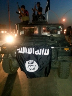 FILE - Islamic State display their flag during celebrations in Mosul, Iraq.
