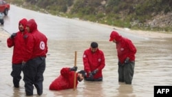 Picha hii iliyotolewa na Shirika la Mwezi mwekundu nchini Libya Septemba 11, 2023, inaonyesha wafanyakazi wake wakifanya kazi kufungua barabara zilizokumbwa na mafuriko katika eneo lisilojulikana mashariki mwa Libya.