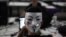 A man wearing a Guy Fawkes mask surfs the web during a "Campus Party" Internet users gathering in Sao Paulo, January 30, 2013.