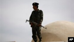Soldier stands guard outside state security court where suspected al-Qaida militants attend hearing, Sanaa, April 22, 2014.