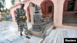 An Indian security personnel walks next to bloody footprints inside the Mahabodhi temple complex, after a series of explosions at Bodh Gaya in the eastern Indian state of Bihar, July 7, 2013.