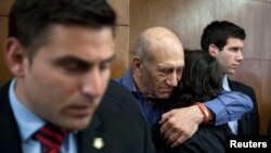 Mantan Perdana Menteri Israel Ehud Olmert (kedua dari kiri) memeluk seorang perempuan saat menanti vonisnya di Pengadilan Negeri Tel Aviv District Court tahun lalu.