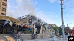 우크라이나 도네츠크주 크라마토르스크에 있는 '리아 피자' 음식점에 27일 러시아 미사일이 강타한 직후 주민이 현장을 바라보고 있다. (크라마토르스크 당국 제공)