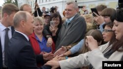 Russia's President Vladimir Putin (L) meets with local residents in the Siberian city of Omsk, Russia, Aug. 28, 2018. 