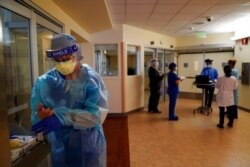 FILE - Registered nurse Merri Lynn Anderson puts on her protective equipment to check on her patient in a COVID-19 unit at St. Joseph Hospital in Orange, Calif., Jan. 7, 2021.