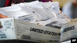 រូបឯកសារ៖ អ្នកធ្វើការ​នៅ​ការិយាល័យ​បោះឆ្នោត​កាន់​ប្រអប់​ដាក់​សន្លឹកឆ្នោត ខណៈដែល​ការរាប់​សន្លឹកឆ្នោត​នៅតែ​បន្ត​ធ្វើ​នៅ​ទីក្រុង Atlanta កាលពី​ថ្ងៃទី៥ ខែវិច្ឆិកា ឆ្នាំ២០២០។