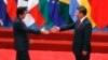 FILE - Japanese Prime Minister Shinzo Abe, left, and Chinese President Xi Jinping approach each other for a handshake before a group photo session for the G-20 Summit in Hangzhou, in eastern China's Zhejiang province, Sept. 4, 2016. The two will meet Thursday, when Abe starts a three-day visit to China.