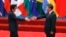 FILE - Japanese Prime Minister Shinzo Abe, left, and Chinese President Xi Jinping approach each other for a handshake before a group photo session for the G-20 Summit in Hangzhou, in eastern China's Zhejiang province, Sept. 4, 2016. The two will meet Thursday, when Abe starts a three-day visit to China.