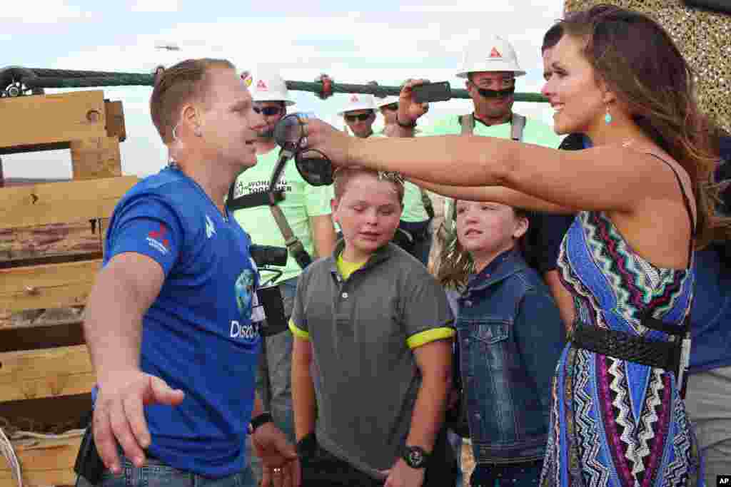Aerialis Nik Wallenda (kiri) disambut istrinya Erendira, setelah berhasil menyeberangi ngarai Grand Canyon di atas kabel baja berdiameter 5 sentimeter tanpa jaring atau tali pengaman (23/6).&nbsp;(AP/Discovery Channel, Tiffany Brown)