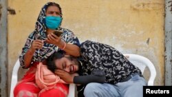 A man mourns after his father died due to the coronavirus disease (COVID-19) outside a mortuary of a COVID-19 hospital in Ahmedabad, India, May 8, 2021. 