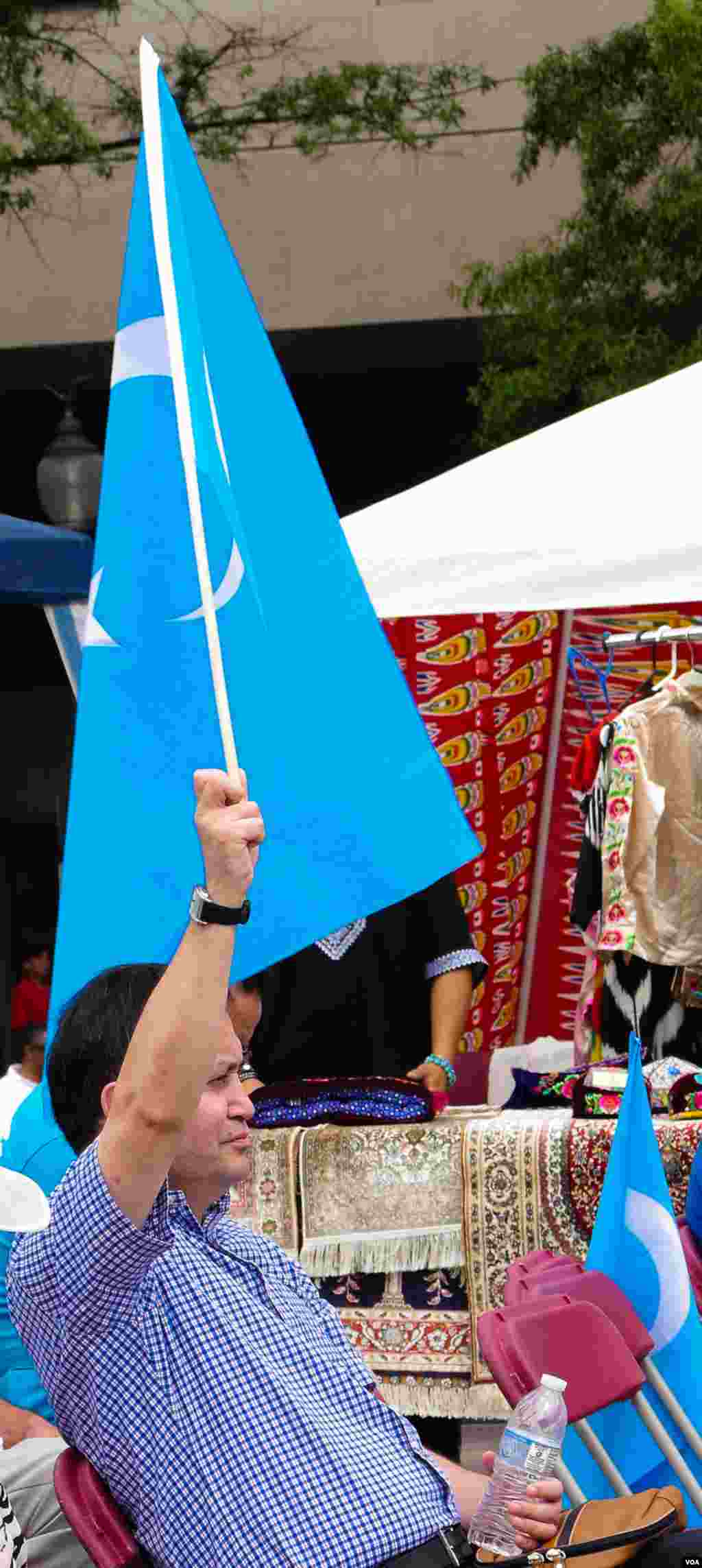 Vashingtonda Uyg&#39;ur madaniy festivali. Uyg&#39;ur-Amerika uyushmasi prezidenti Olim Seytoff Sharqiy Turkiston bayrog&#39;ini ko&#39;tarib turibdi, Vashington, 3-avgust, 2014-yil. Odil Ruzaliev surati