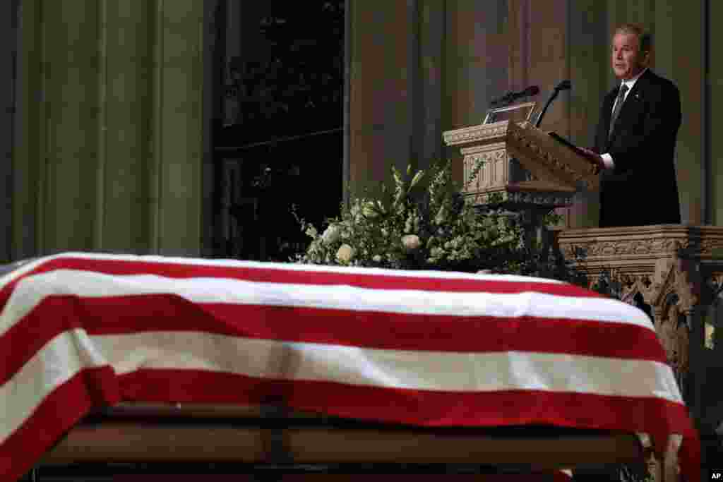 =Former President George W. Bush speaks in front of the flag-draped casket of his father, former President George H.W. Bush, at the State Funeral at the National Cathedral, Dec. 5, 2018, in Washington. 