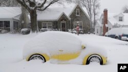 A snow-covered car is parked outside a home in Greensboro, North Carolina, Dec. 9, 2018. A massive storm brought snow, sleet, and freezing rain across a wide swath of the South on Sunday.